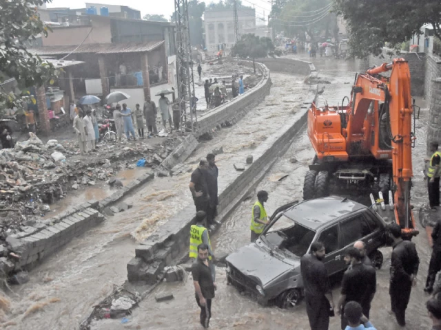 rescue teams scramble to retrieve a submerged car from a raging nullah in islamabad s saidpur village after torrential monsoon rains triggered urban flooding photo online
