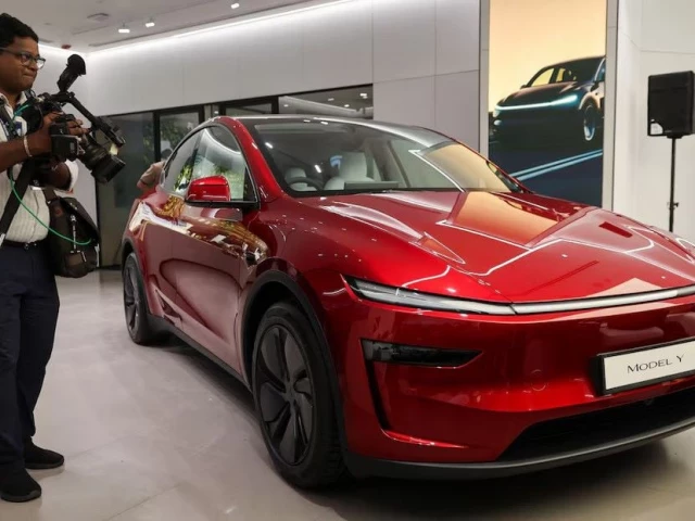 a media personnel walks past a tesla model y car at india s first tesla showroom in mumbai india july 15 2025 photo reuters