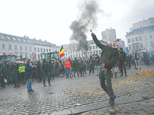 a farmer throws a potato near the european parliament during a farmers protest to denounce the reforms of the cap and trade agreements such as the mercosur in brussels photo afp