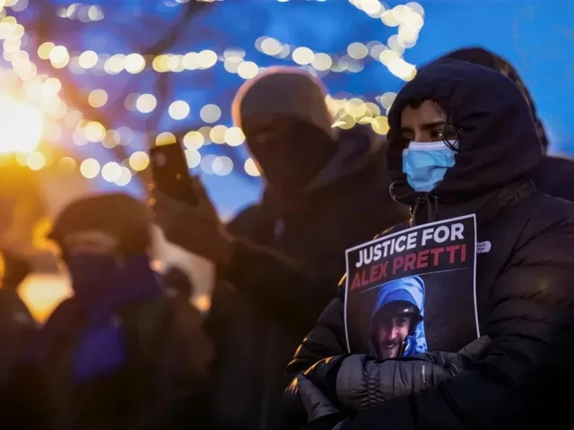 people mourn at a makeshift memorial in the area where 37 year old alex pretti was shot dead by federal immigration agents earlier in the day in minneapolis minnesota on january 24 2026 photo afp