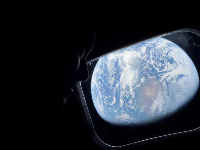 nasa astronaut and artemis ii commander reid wiseman peers out of one of the orion spacecraft s main cabin windows looking back at earth as the crew travels towards the moon april 2 2024 photo nasa