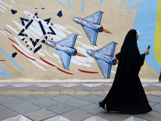 a woman walks next to an anti israeli mural on a street amid a ceasefire between u s and iran in tehran iran april 20 2026 reuters