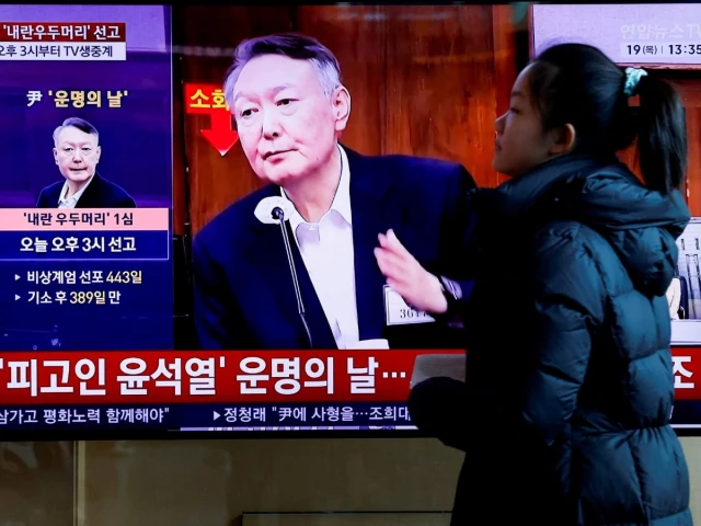 a person walks in front of a tv screen broadcasting a news report on the sentencing trial of south korean former president yoon suk yeol s insurrection case stemming from his short lived declaration of martial law in december 2024 in seoul south korea february 19 2026 photo reuters